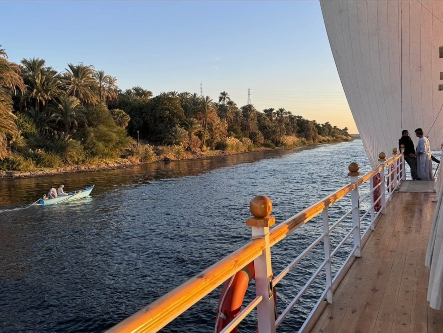 Il passaggio esterno della dahabiya Akhenaton al tramonto sul Nilo