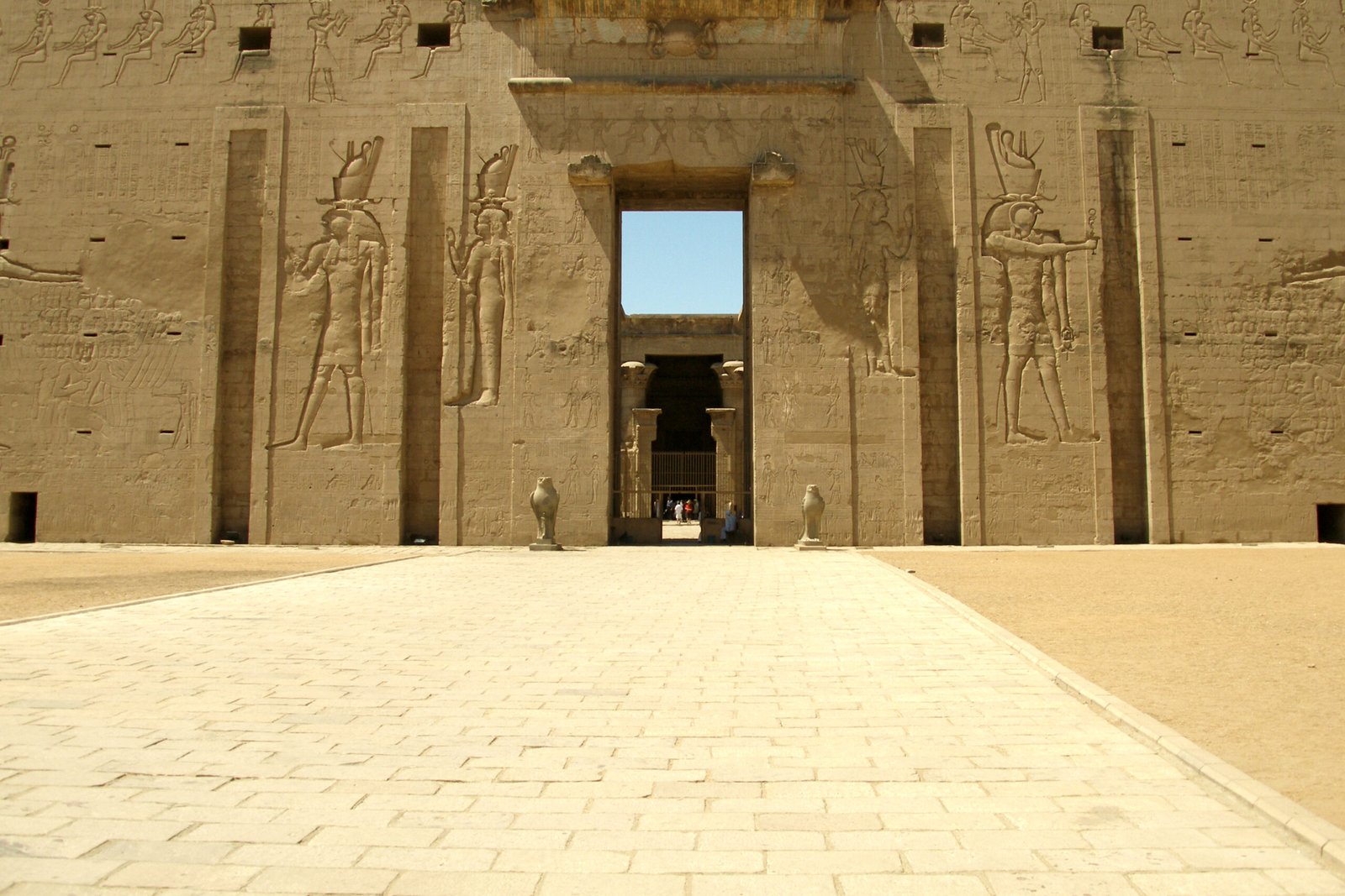 L'ingresso del tempio di Edfu visto dal cortile, con il portale tra i due piloni e il pavimento di pietra chiara