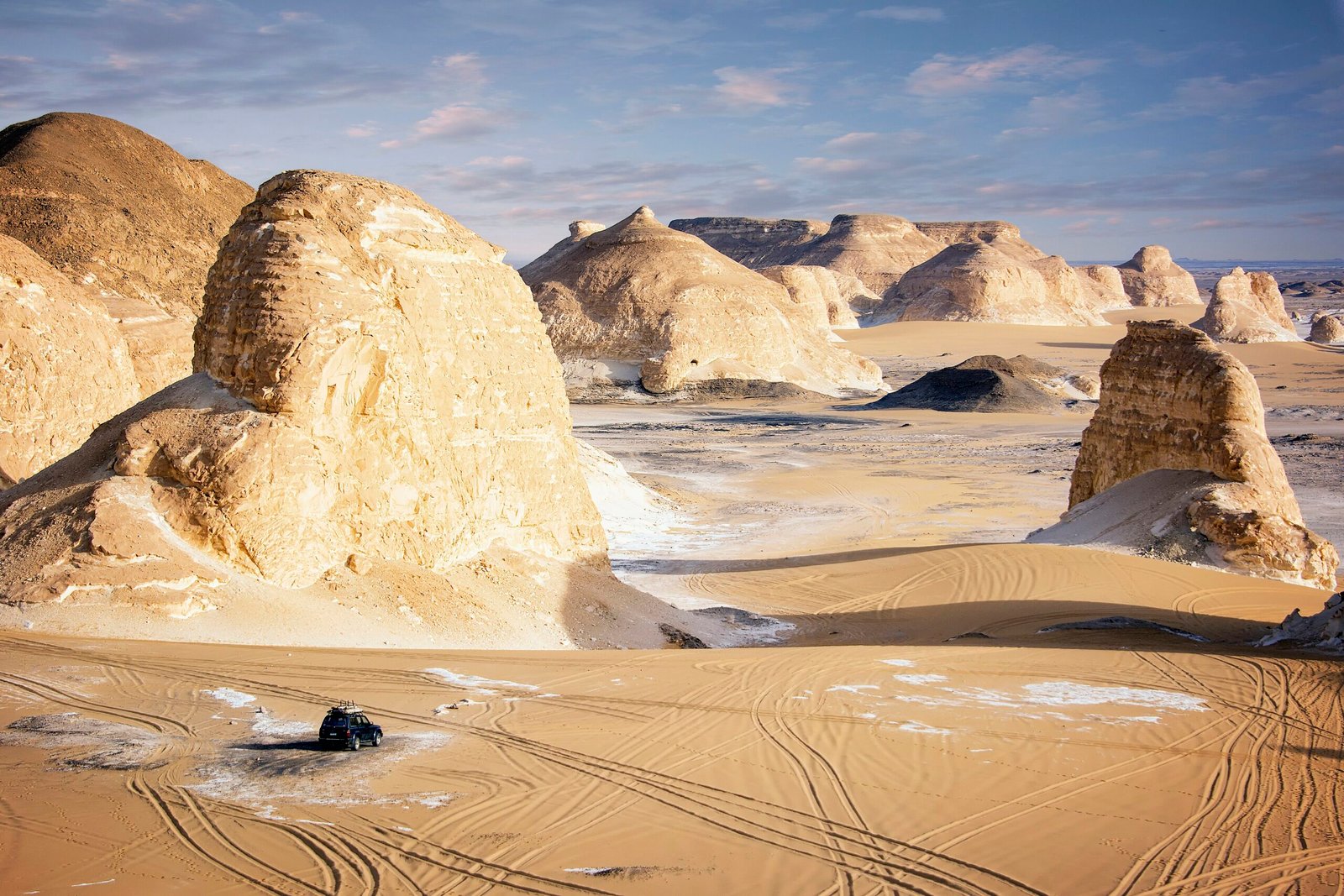 Le rocce di gesso bianco del Deserto Bianco con le tracce dei fuoristrada sulla sabbia dorata