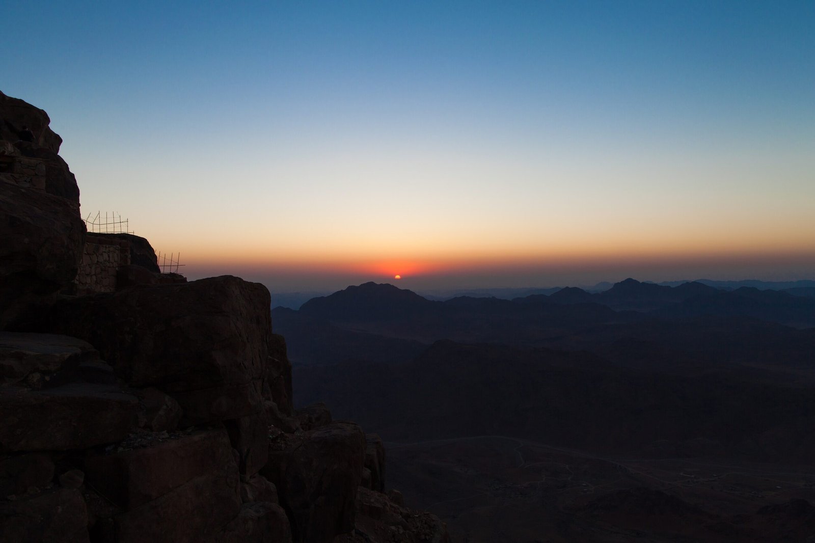 L'alba dalla cima del Monte Sinai, con il sole che sorge sull'orizzonte tra le montagne ancora scure