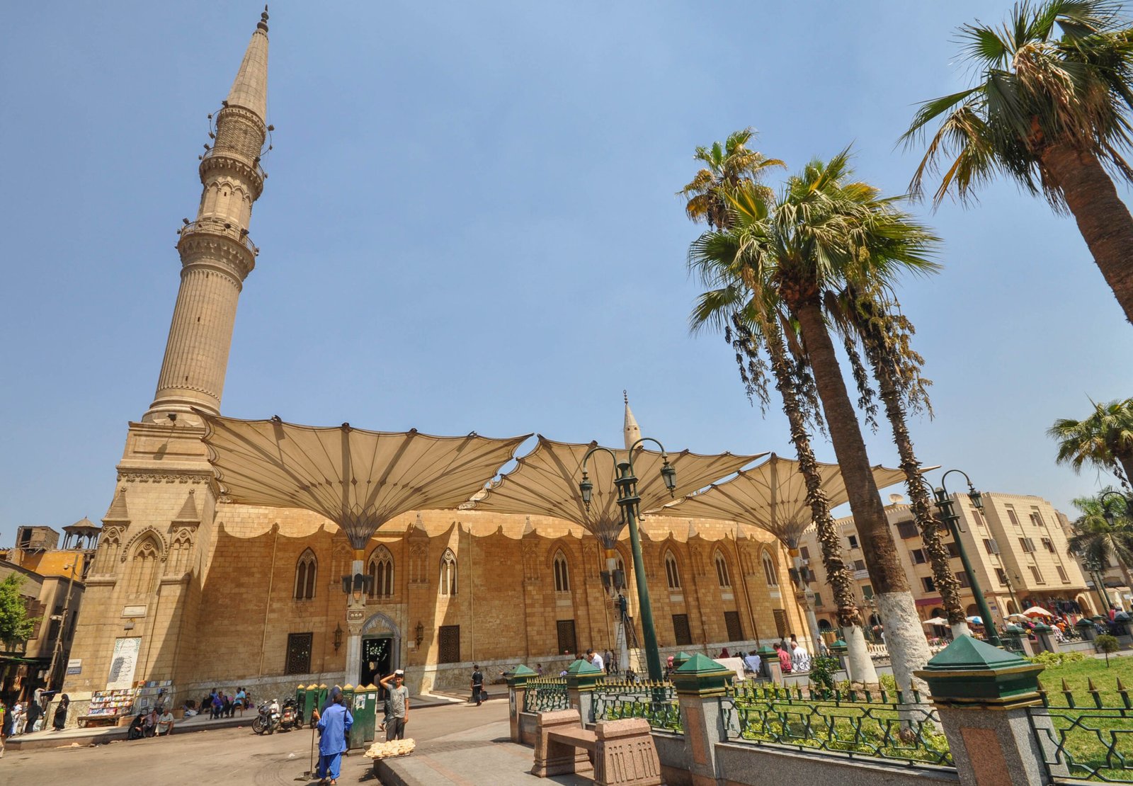 La moschea di Al Hussein al Cairo con il minareto e i grandi ombrelloni bianchi nella piazza