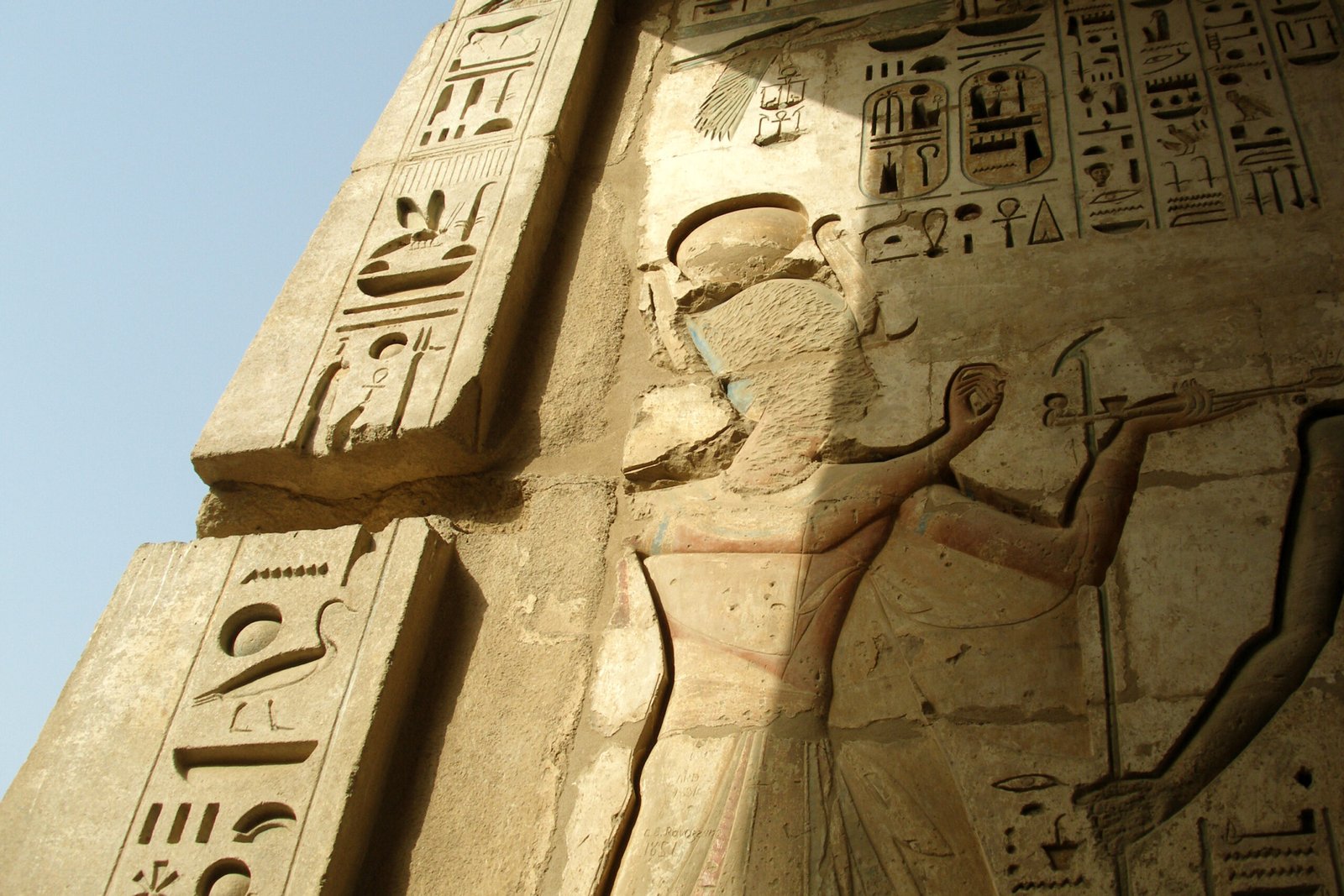 Un rilievo di Ramses III con geroglifici incisi sul pilone di Medinet Habu, contro il cielo azzurro