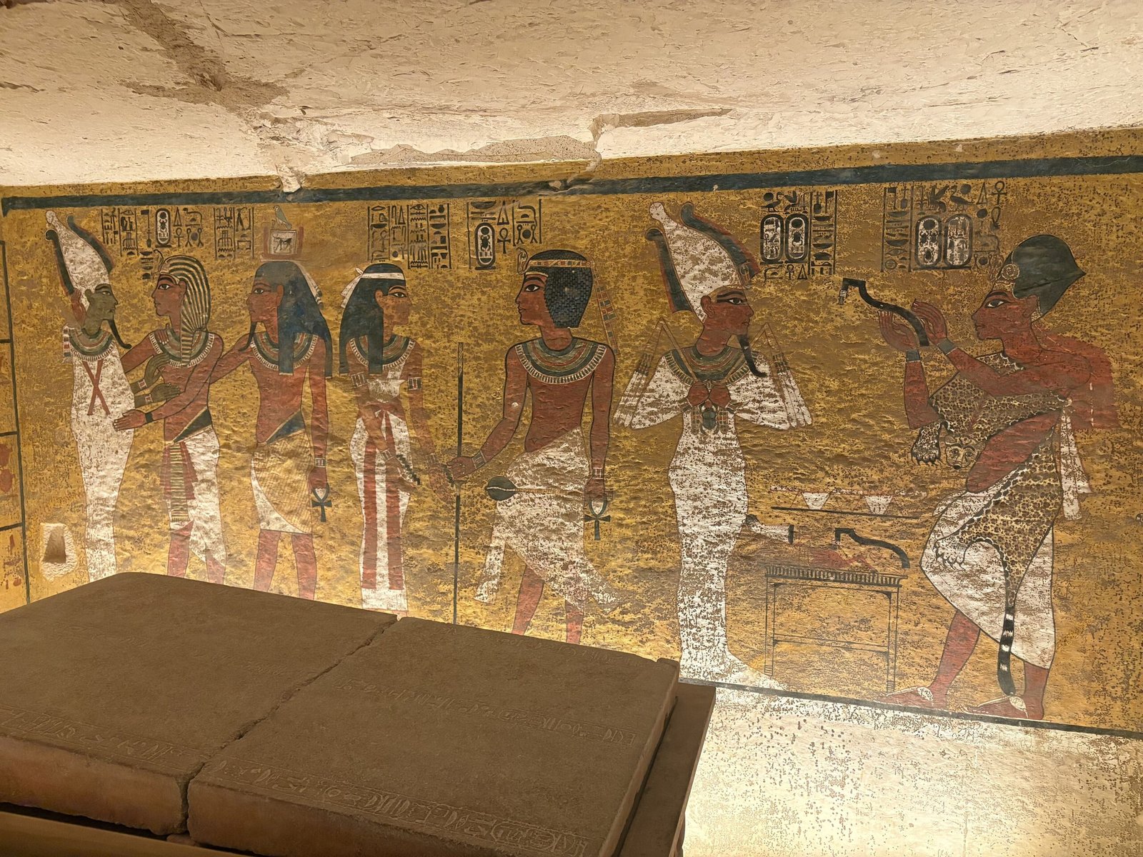 La camera funeraria di Tutankhamon nella Valle dei Re, con le pareti dipinte su fondo giallo e il sarcofago di pietra in primo piano