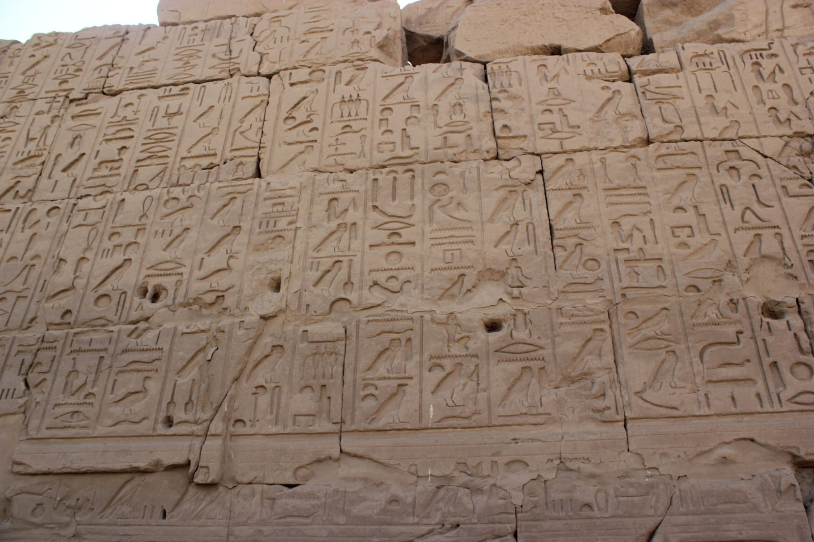 Un muro di blocchi di pietra coperto di geroglifici incisi nel complesso di Karnak