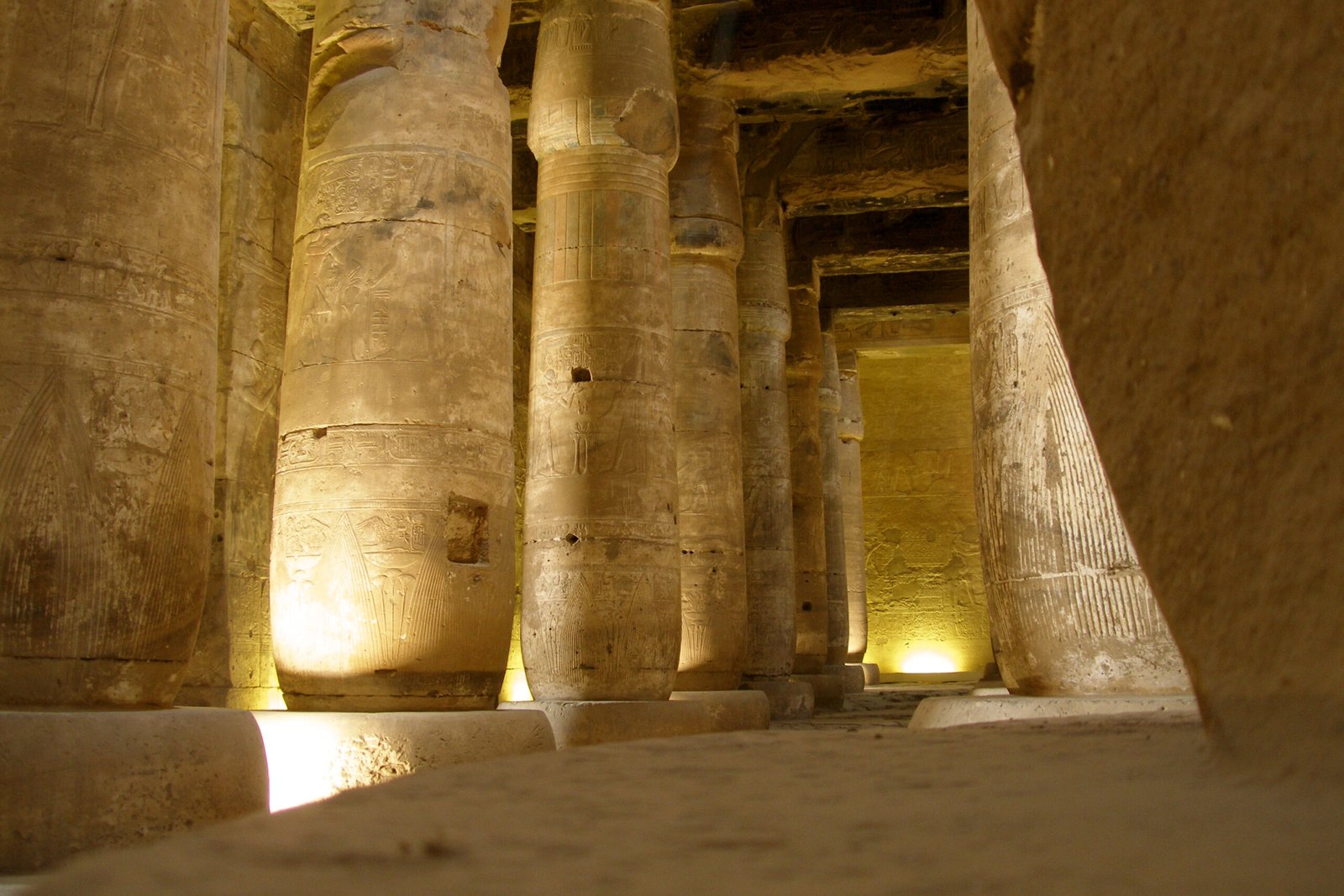 La sala a colonne del tempio di Seti I ad Abydos, illuminata dalle luci calde tra i fusti massicci