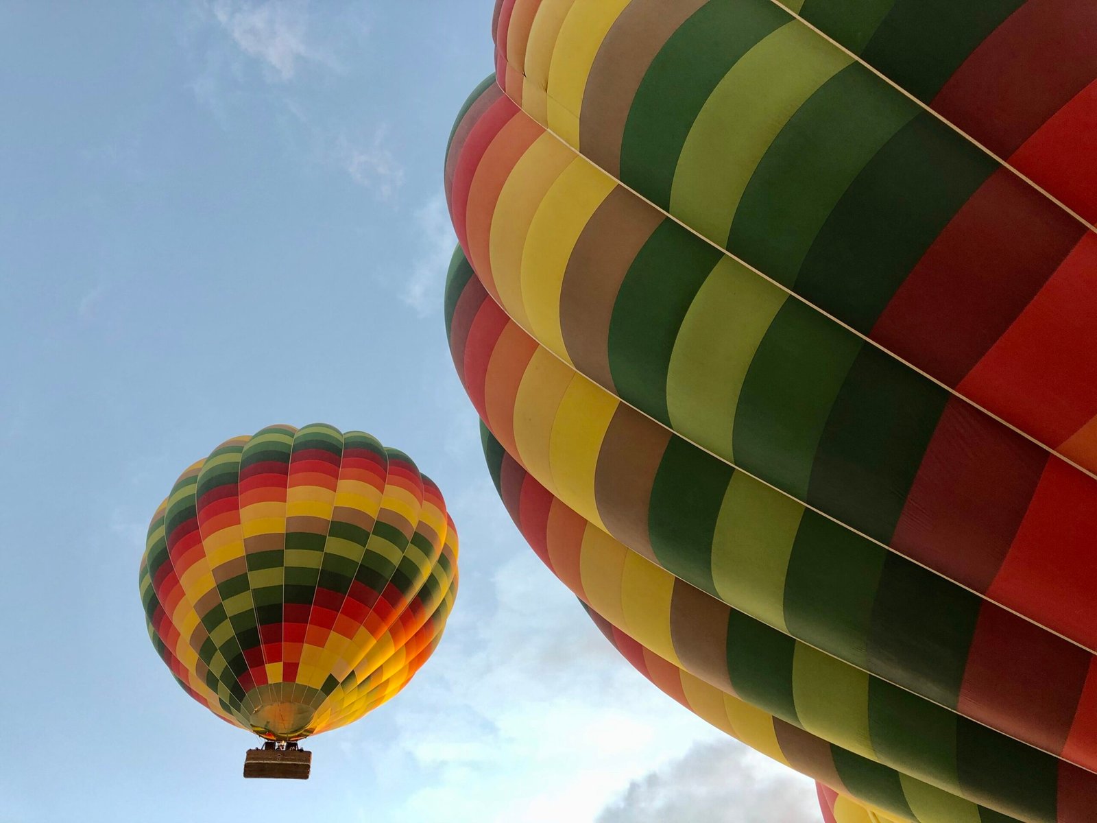 Due mongolfiere dai colori vivaci nel cielo di Luxor, una in primo piano e una più lontana