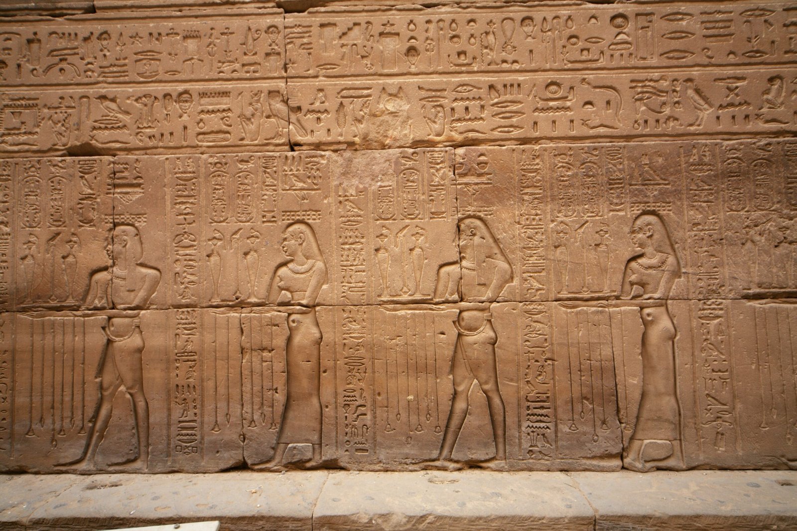 I rilievi e i geroglifici sul muro del tempio di Edfu, con le figure in fila