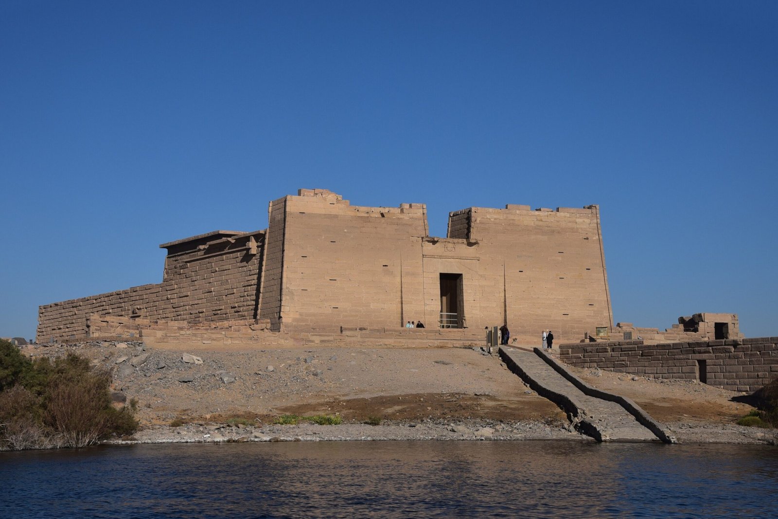 Il tempio di Kalabsha sulla riva del lago Nasser, con la scalinata che scende all'acqua e il cielo blu intenso