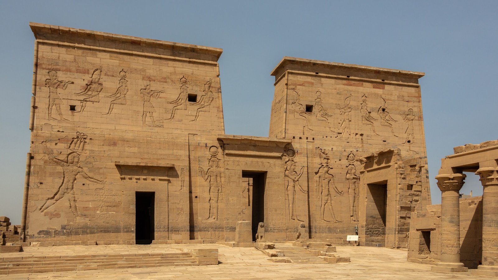 Il primo pilone del tempio di Philae visto dal cortile, con i rilievi sulle facciate delle due torri