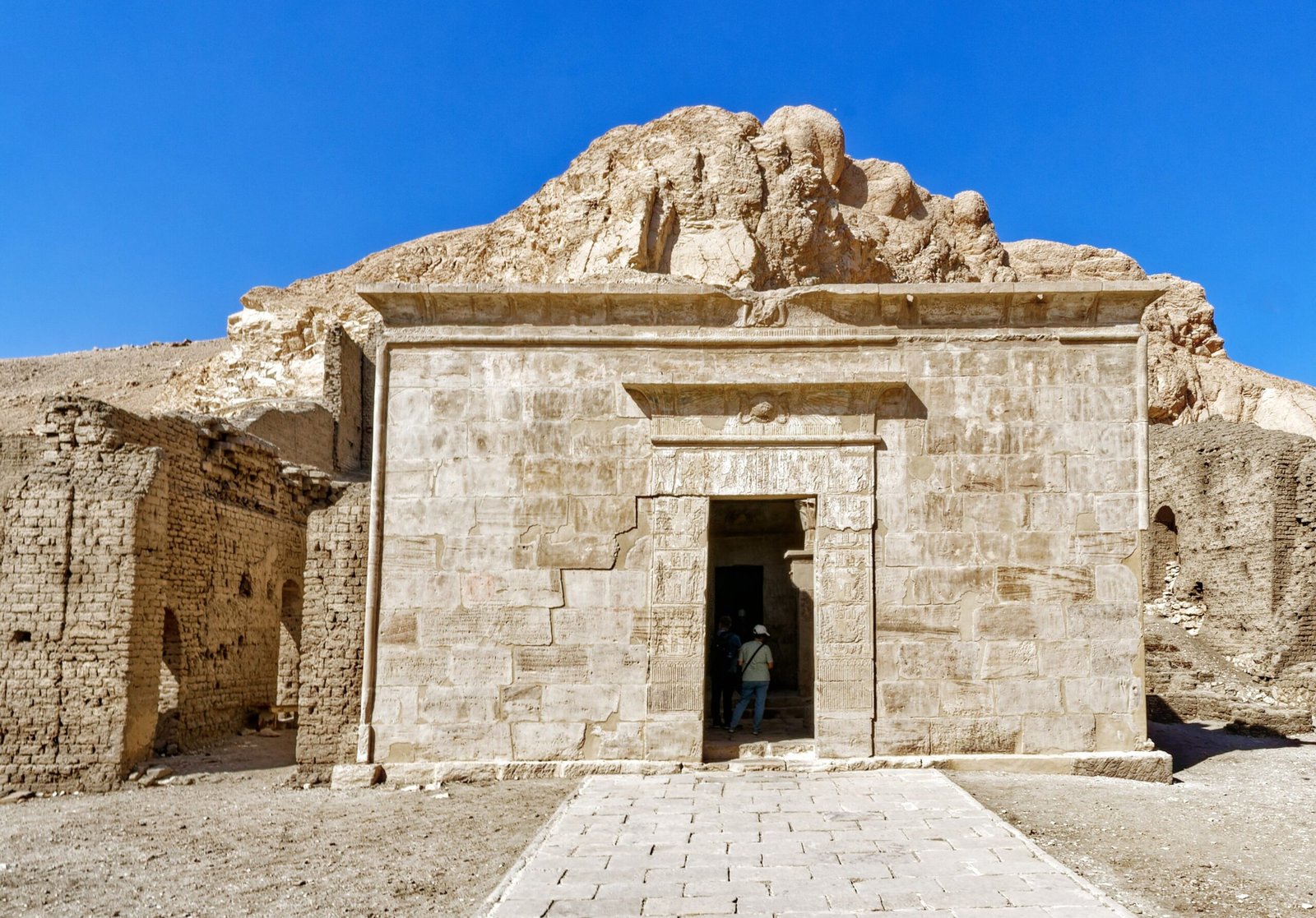 Il piccolo tempio tolemaico di Hathor a Deir el-Medina, con il portale di pietra e la collina alle spalle