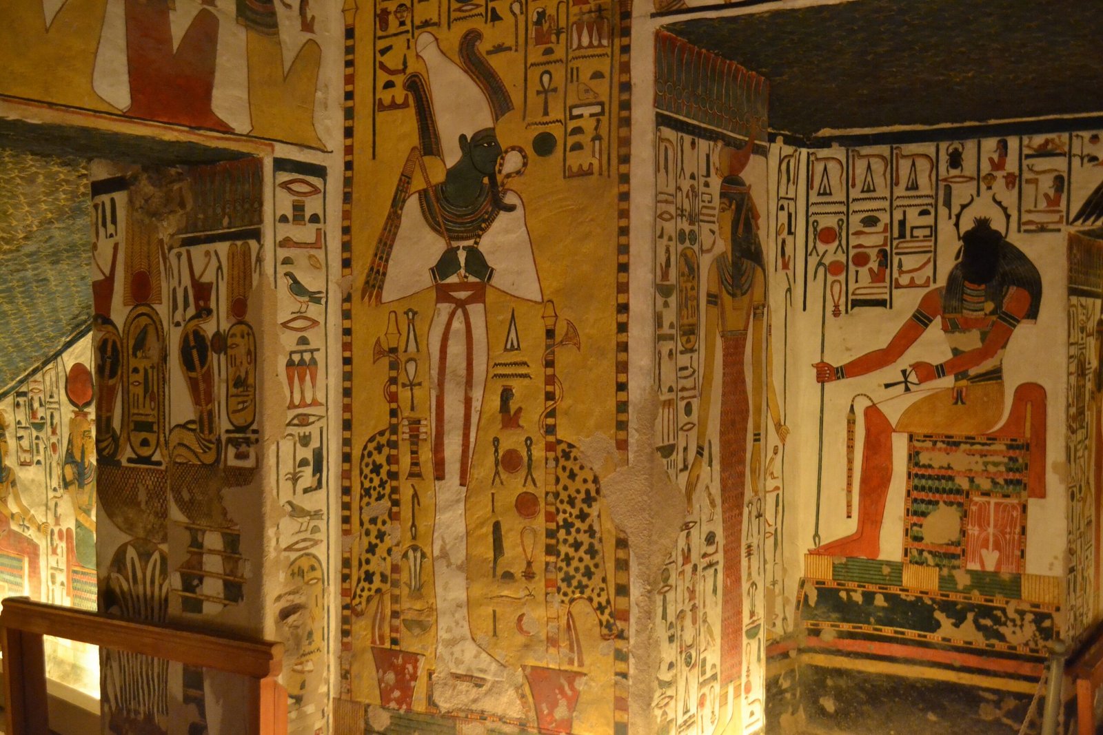 Osiride e altre divinità dipinte su una parete della tomba di Nefertari, nella luce calda dei faretti