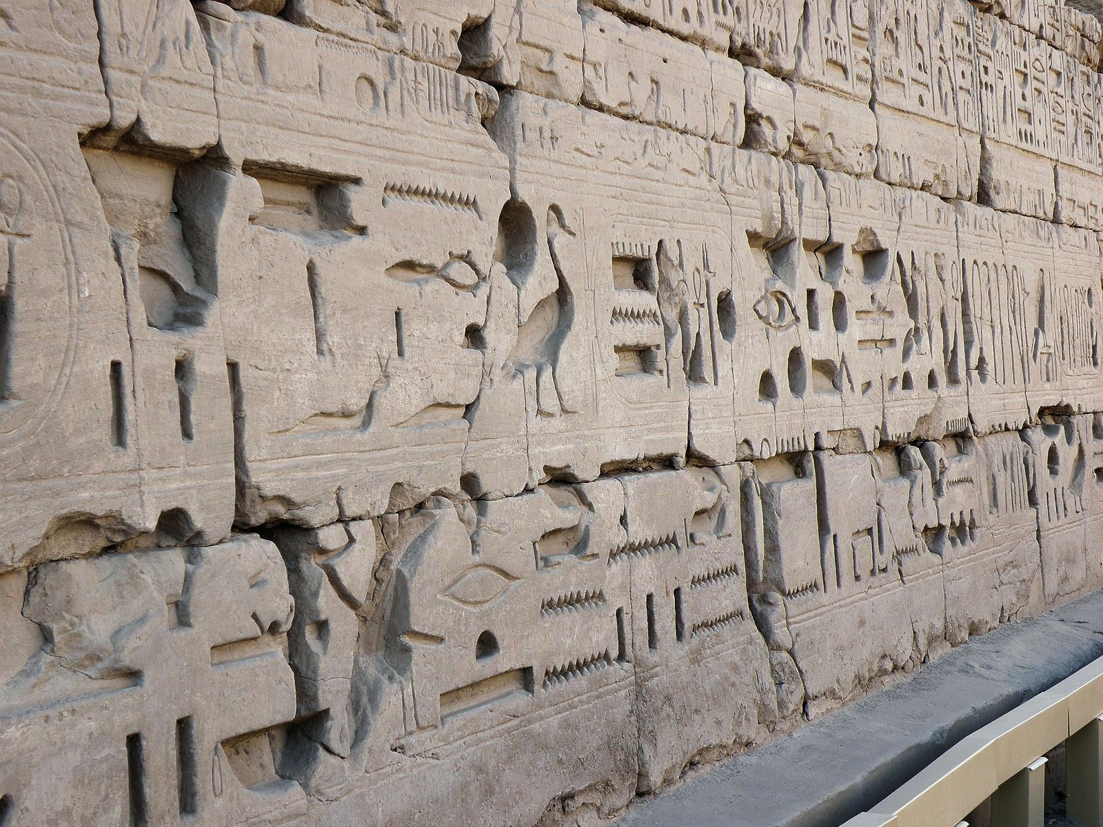 Una parete di geroglifici scolpiti in profondità sul muro del tempio di Karnak, con i blocchi di pietra