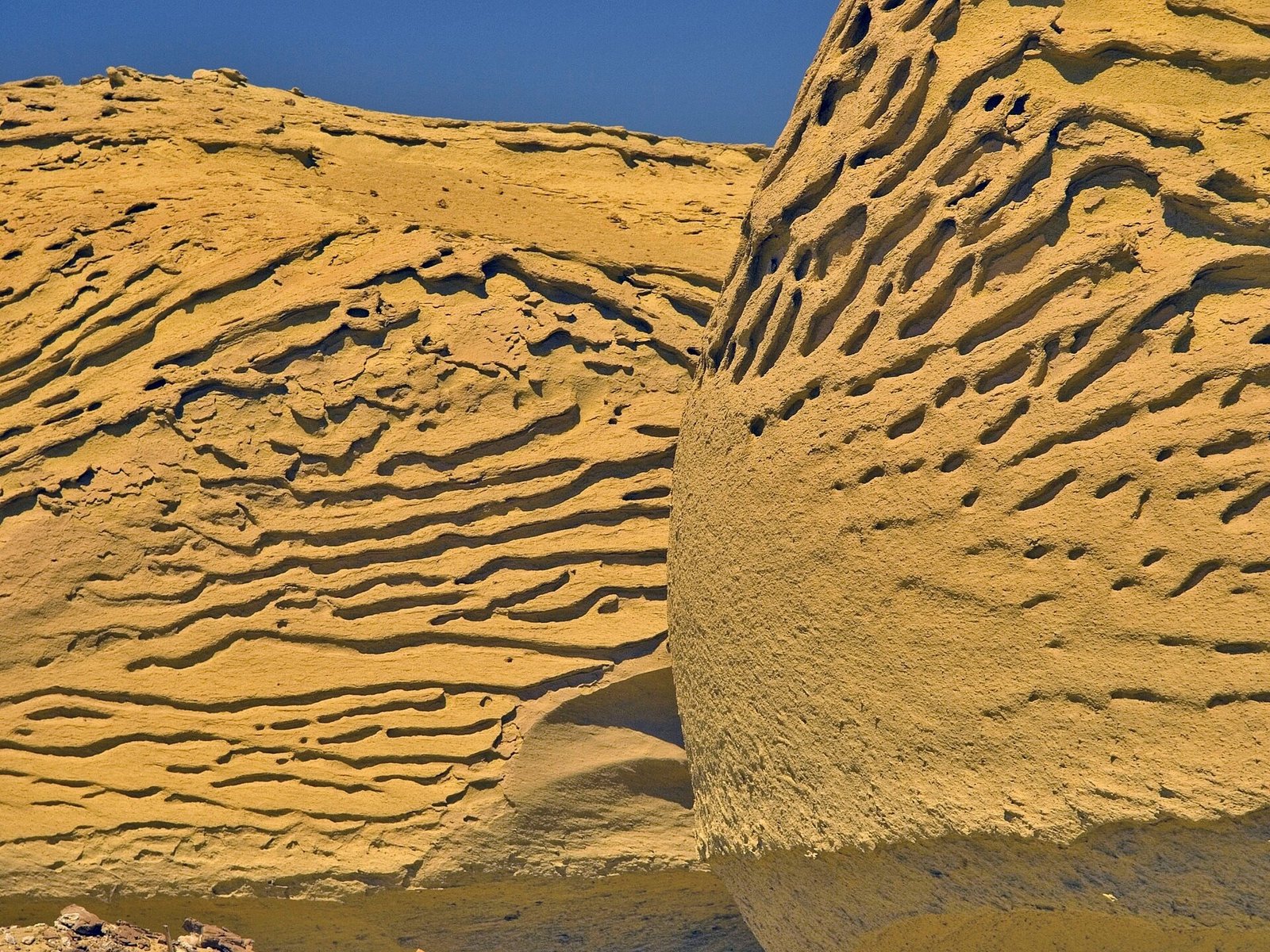 Formazioni di arenaria erose dal vento a Wadi el-Hitan, con le linee degli strati nella roccia dorata